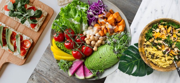 Bowl filled with vegetables, grains, and avocado on a kitchen counter